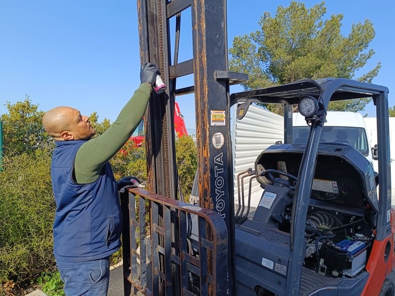 Photo d'un technicien qui réalise un entretien - maintenance sur un chariot élévateur